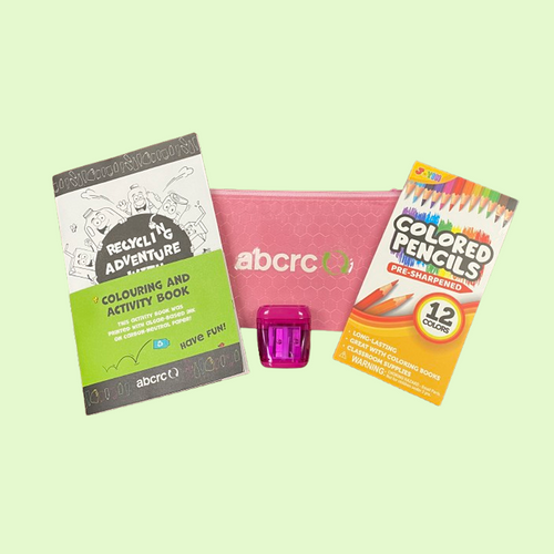 Coloring book, pink pouch, and colored pencils on a light green background
